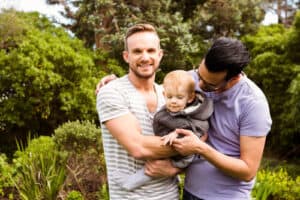 Gay couple with child in the garden